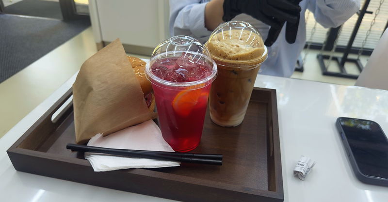 A tray with two red mors drinks and a kraft bag