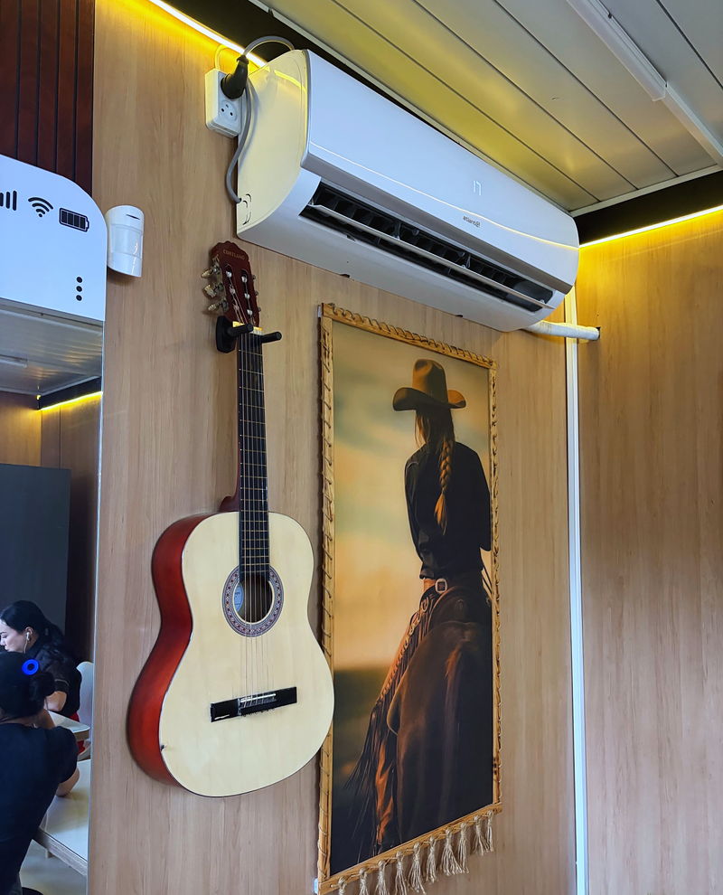 A guitar and a poster on the room’s wooden wall