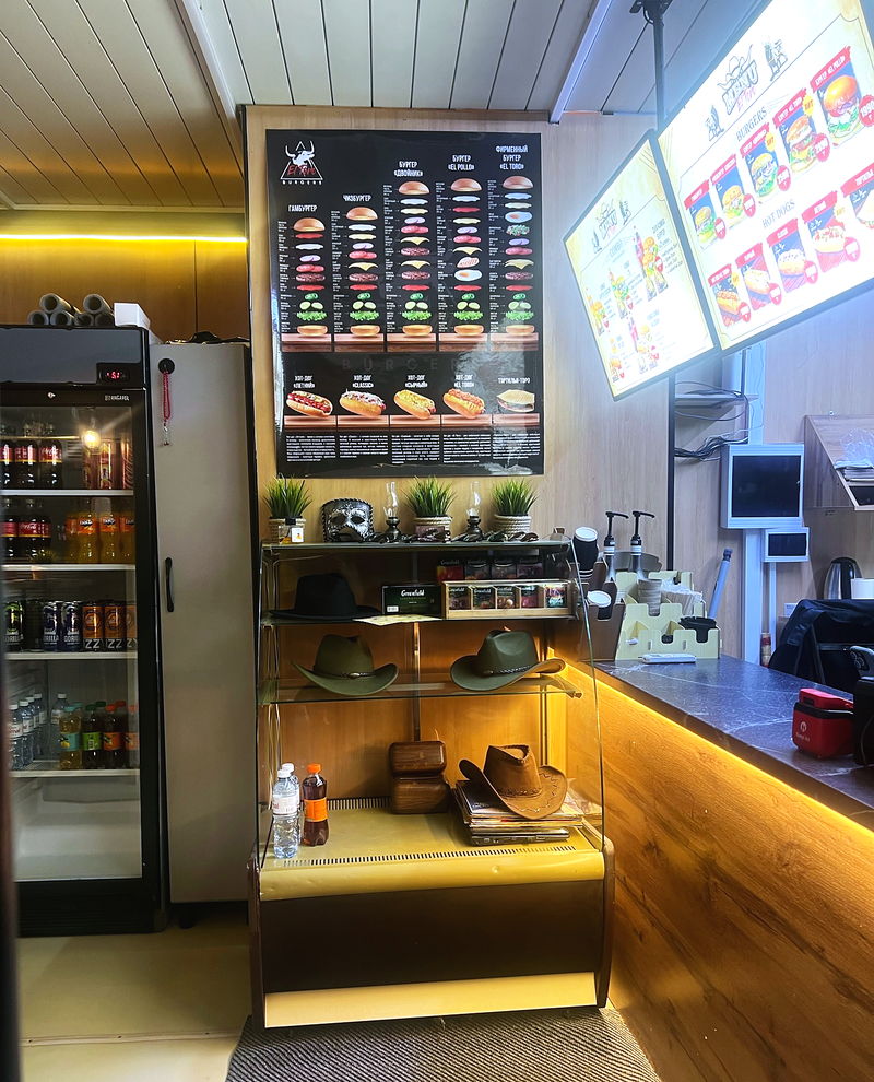 The counter with the drinks fridge and the menu boards