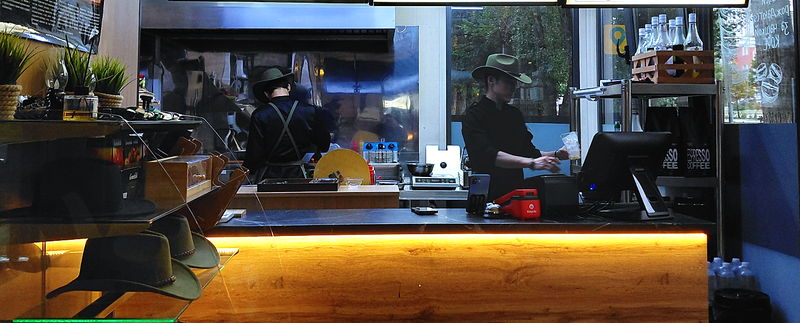 The El Toro counter: a cook and a cashier in cowboy hats behind the wooden bar