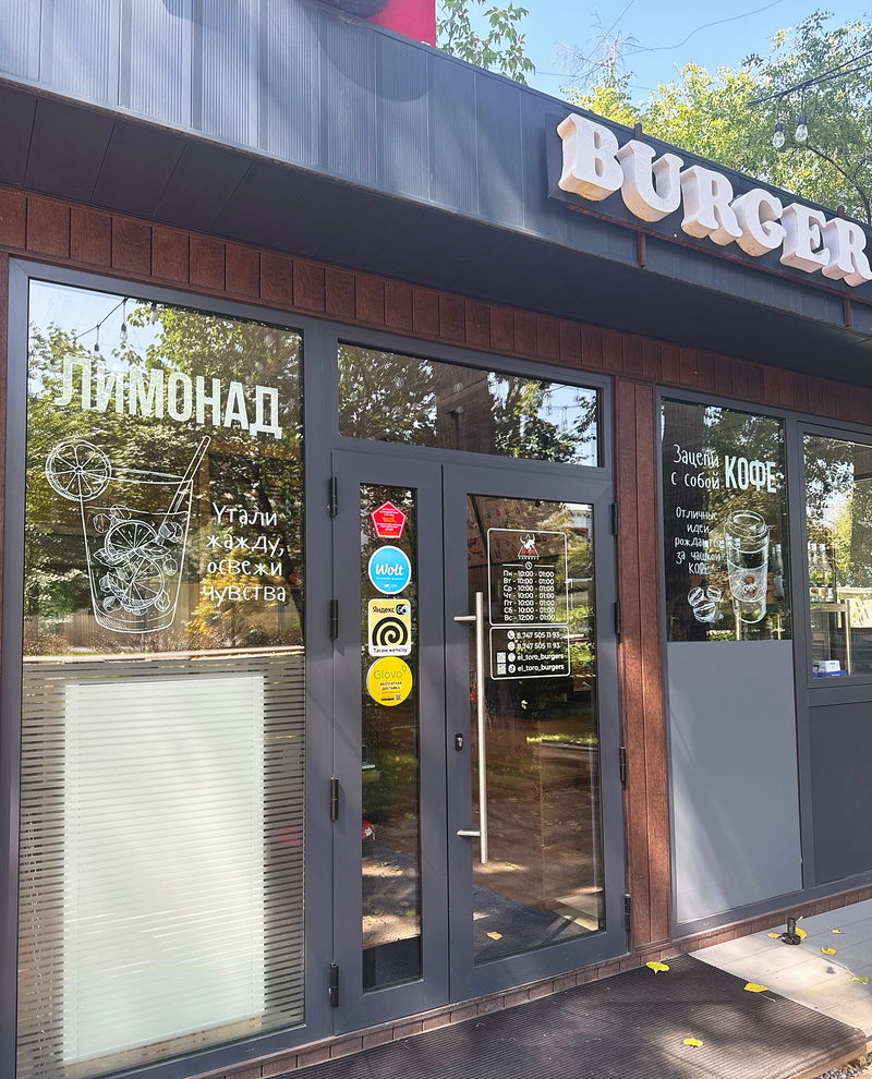 The El Toro shopfront on Abay among the trees, with “BURGER” and “ЛИМОНАД” signs